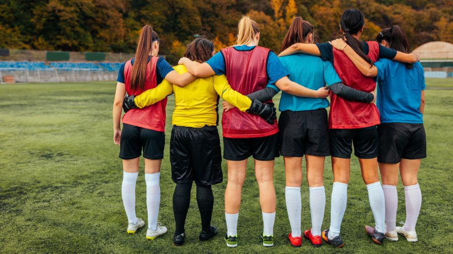 Soccer players in colorful shirts, standing together.