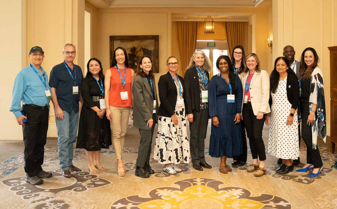 group of people standing on carpeted surface of hotel ballroom space
